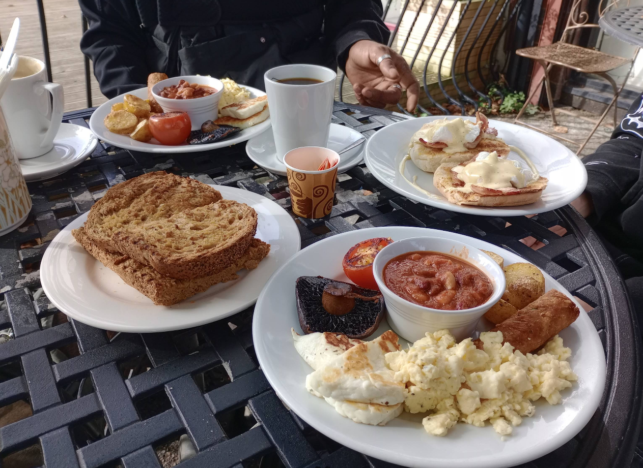 Brunch plates outside with eggs benedict and full breakfast