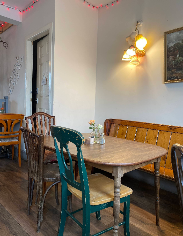 Cosy dining nook with green chair and pew bench