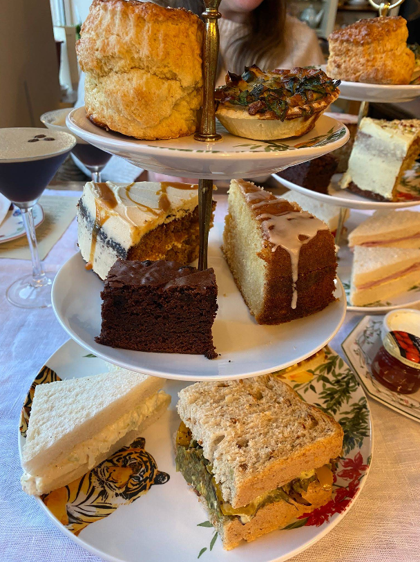 Three-tier cake stand with brownies, cakes and sandwiches