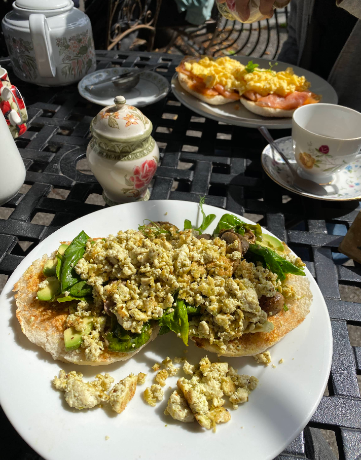 Tofu scramble on toasted muffin with avocado and greens
